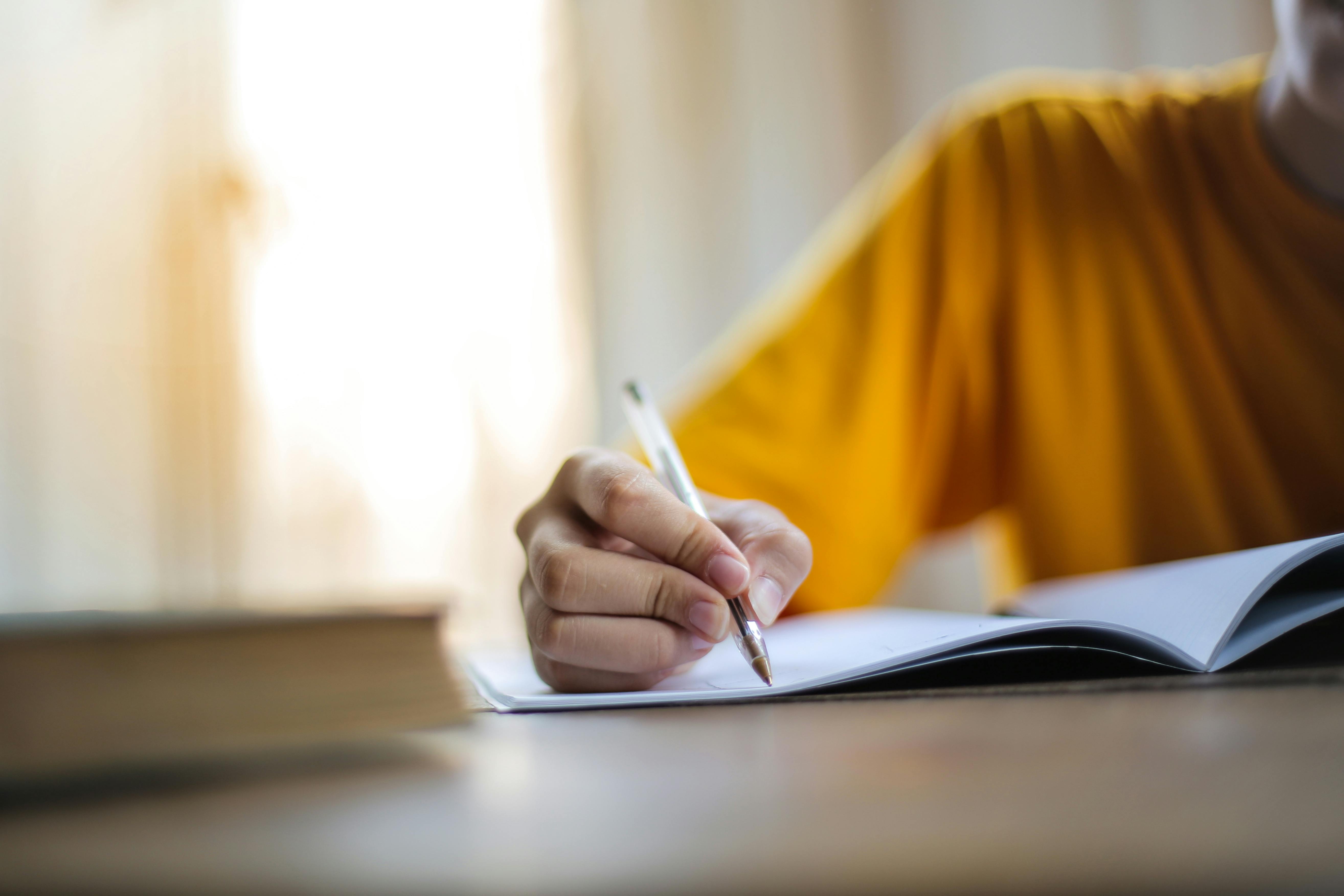 Person writing in a notebook | Source: Pexels