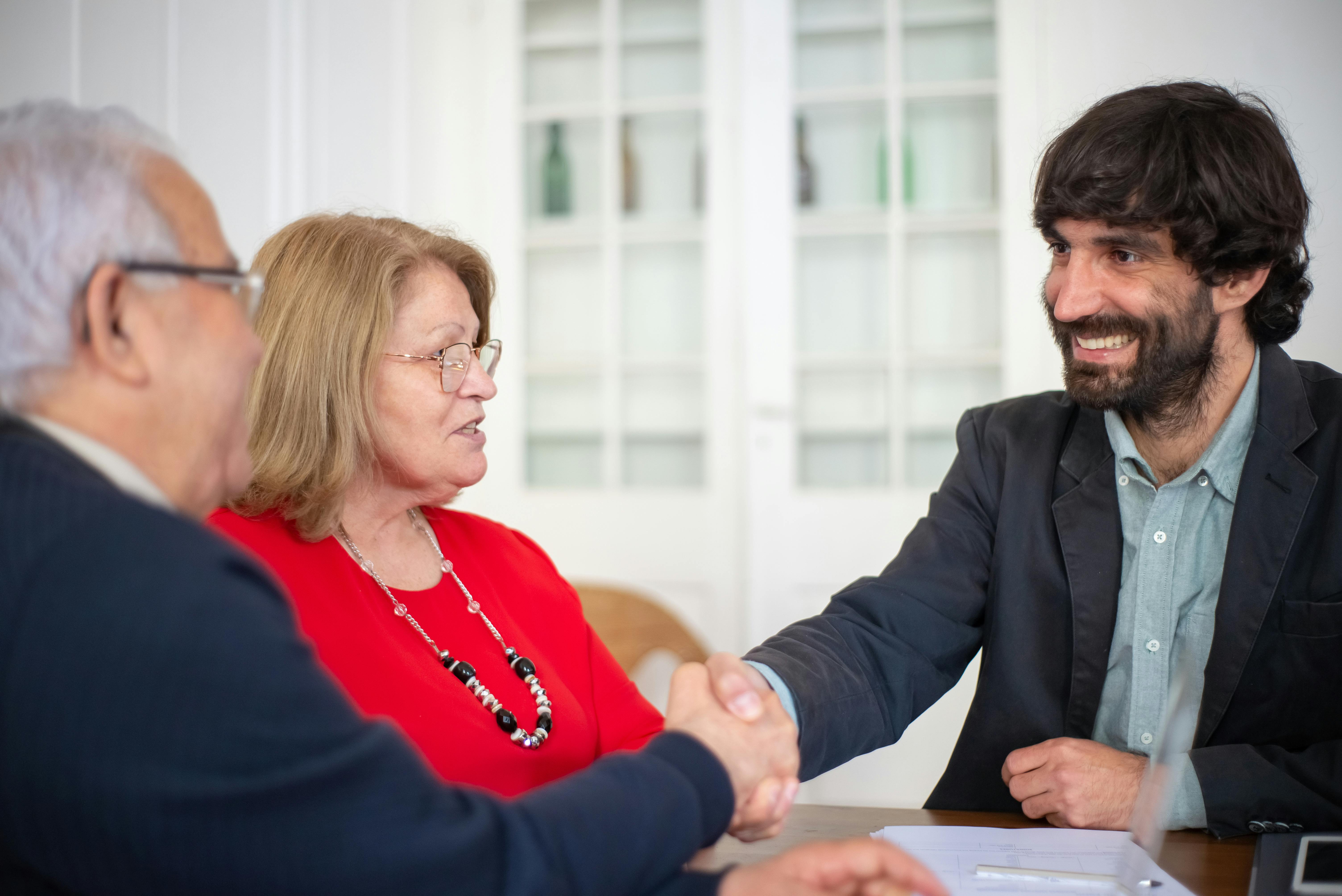 People smiling and shaking hands | Source: Pexels