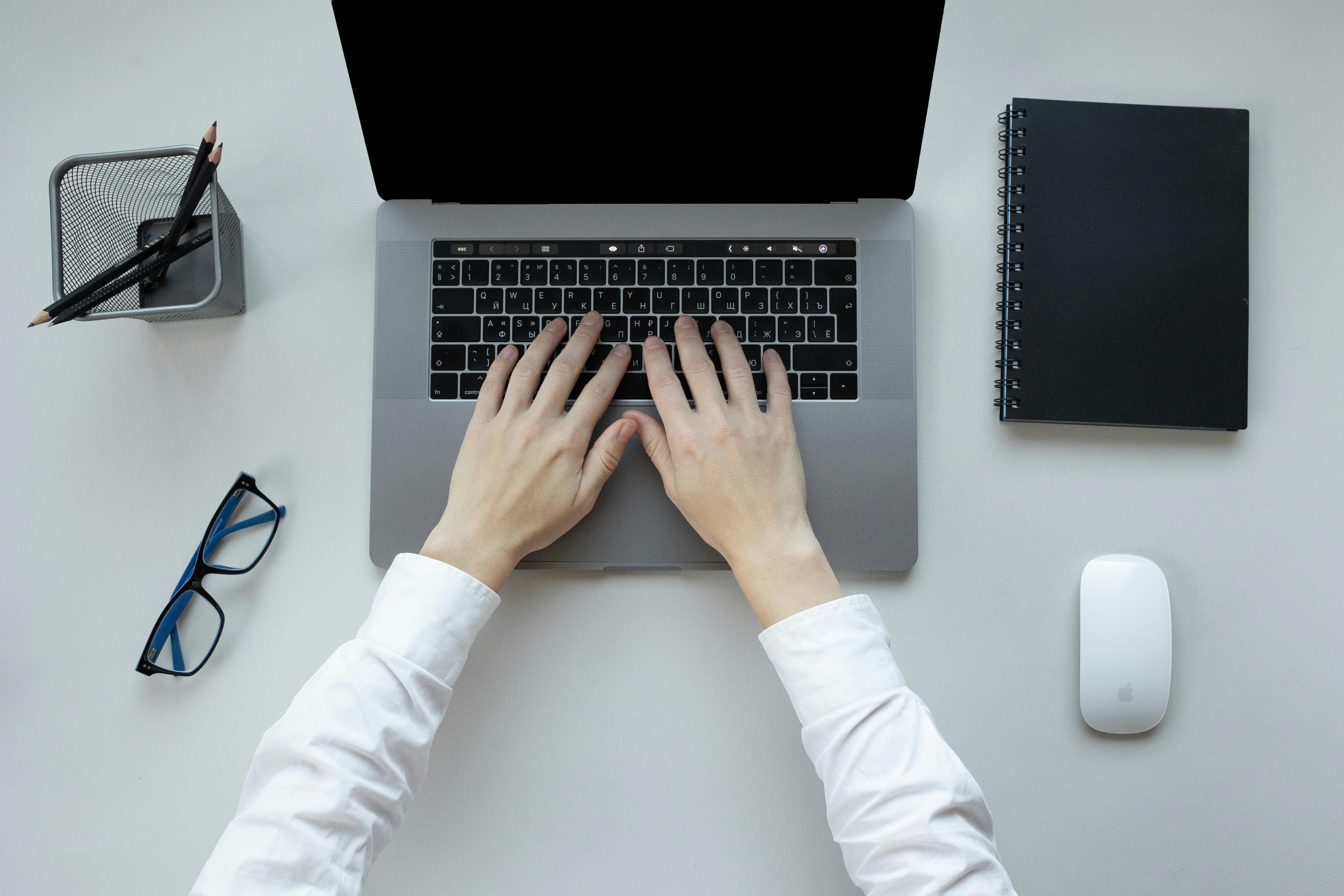 Laptop and black notebook on the table | Source: Pexels