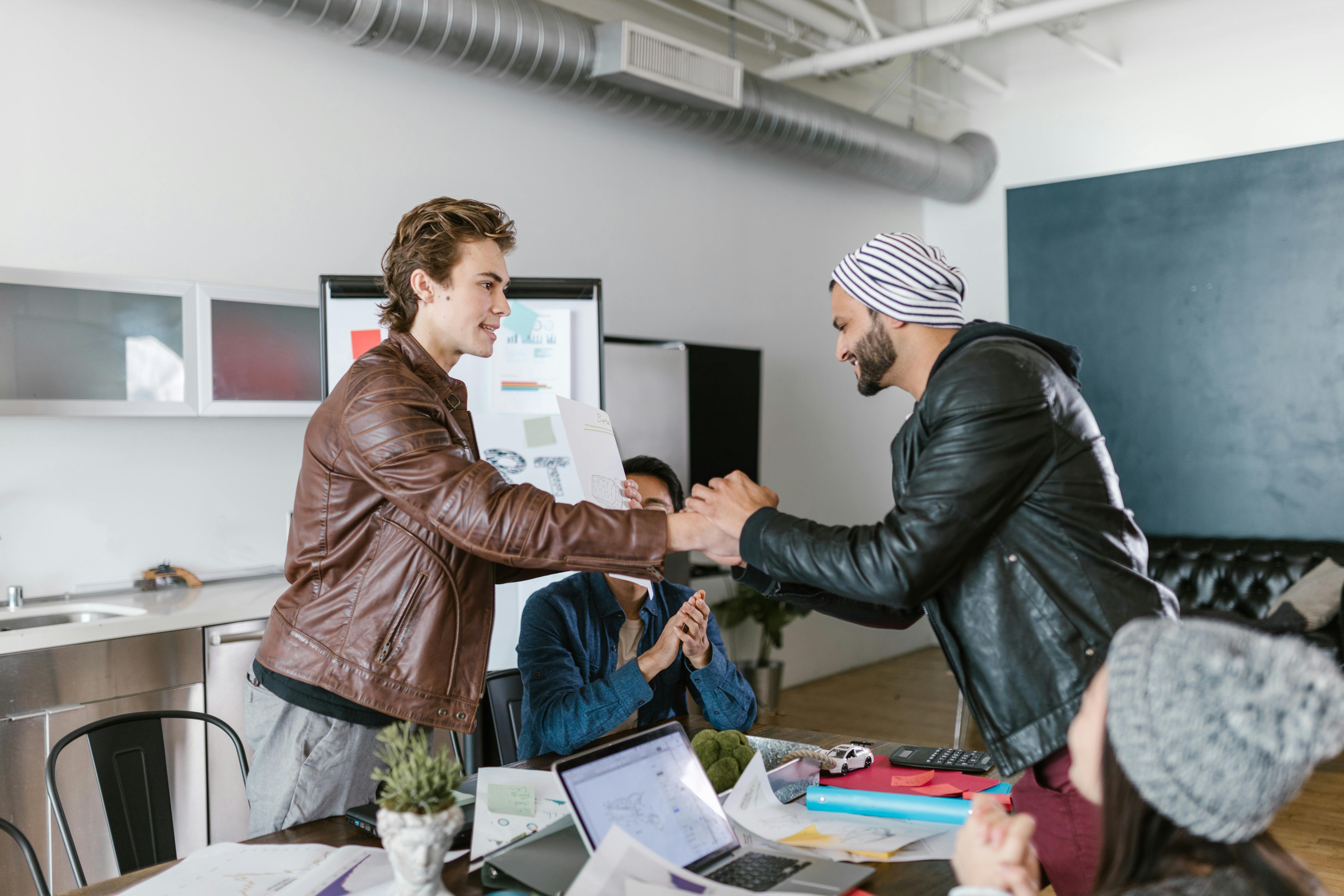 Men in leather jackets shaking hands | Source: Pexels